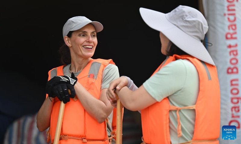 Laura Mora (L), a Spanish engineer from Airbus China, talks with teammate of Airbus China dragon boat team in north China's Tianjin on June 6, 2024. (Photo: Xinhua)