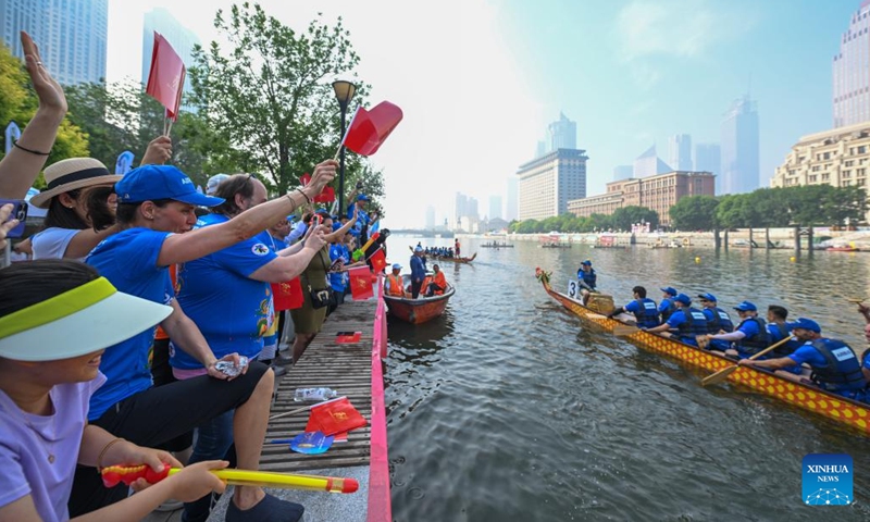 Laura Mora (front 2nd L), a Spanish engineer from Airbus China, greets teammates after preliminaries during the 2024 Haihe Dragon Boat Race in north China's Tianjin on June 10, 2024. (Photo: Xinhua)