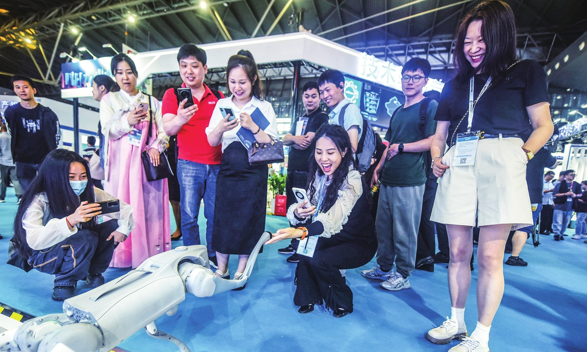 Visitors at the 10th China (Shanghai) International Technology Fair interact with a robot dog on display on June 12, 2024. The three-day exhibition has five sectors and features the latest technologies from nearly 1,000 domestic and overseas enterprises. Photo: VCG