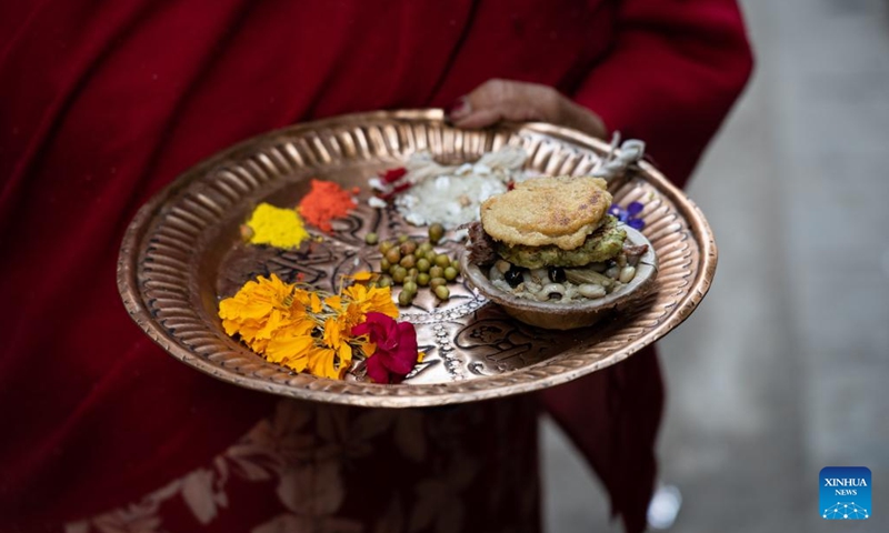 A Newar Woman is about to offer traditional pancakes to the god on the occasion of the Sithi Nakha Festival in Lalitpur, Nepal, June 12, 2024. The Newar community celebrates the Sithi Nakha festival to mark the beginning of monsoon season by cleaning water sources such as ponds, wells and stone spouts. People also prepare traditional pancakes such as Bara and Chatamari as a tribute to their ancestral god.(Photo: Xinhua)