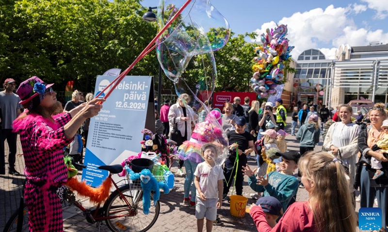 Children enjoy a soap bubble performance at Malmi Suburb during Helsinki Day in Helsinki, Finland on June 12, 2024. June 12 marks Helsinki's birthday, or Helsinki Day, during which residents and tourists will gather to celebrate, turning the entire city into a large carnival.(Photo: Xinhua)