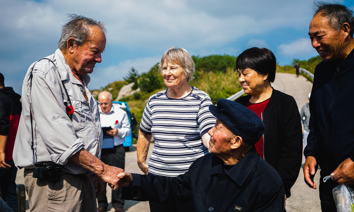 A relative of a British POW shakes hands with Chinese fisherman Lin Agen (with hat) who helped rescue POWs during the sinking of the <em>Lisbon Maru</em> in 1942, in October 2019. Photo: Courtesy of the production team