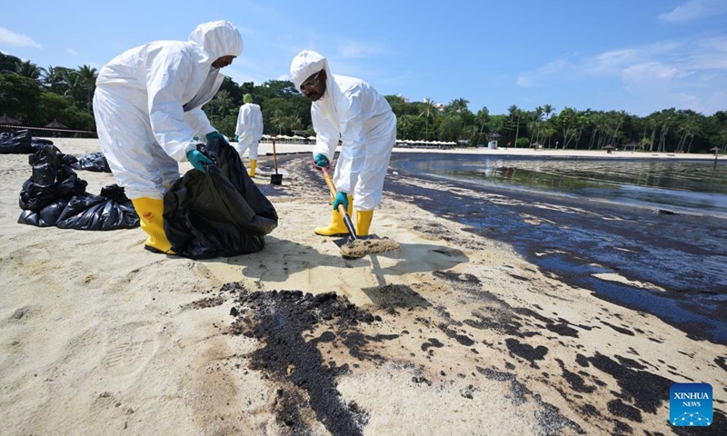 Workers clean up the oil spill on Tanjong beach on Sentosa island in Singapore, June 16, 2024. (Photo: Xinhua)