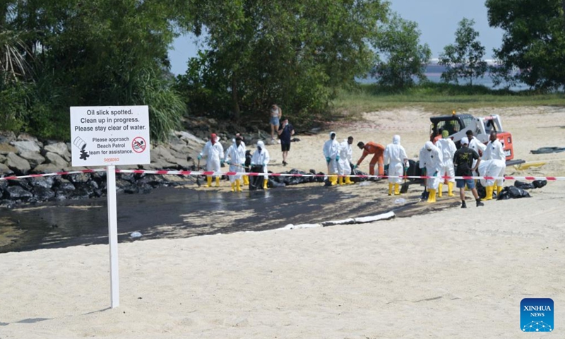 Workers clean up the oil spill on Tanjong beach on Sentosa island in Singapore, June 16, 2024. (Photo: Xinhua)