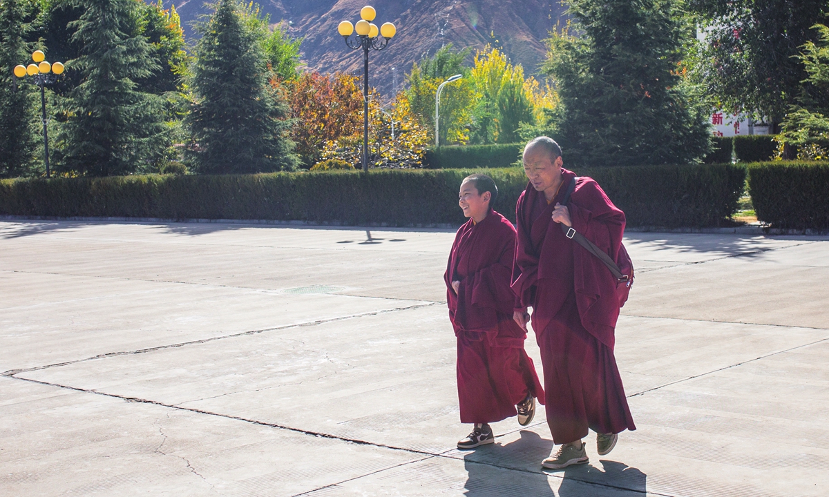 A young Living Buddha and his personal attendant walk in campus after class. Photo: Shan Jie/GT