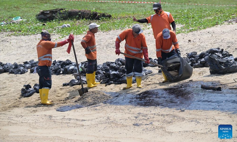 Workers clean up the oil spill on Tanjong beach on Sentosa island in Singapore, June 16, 2024.
(Photo: Xinhua)