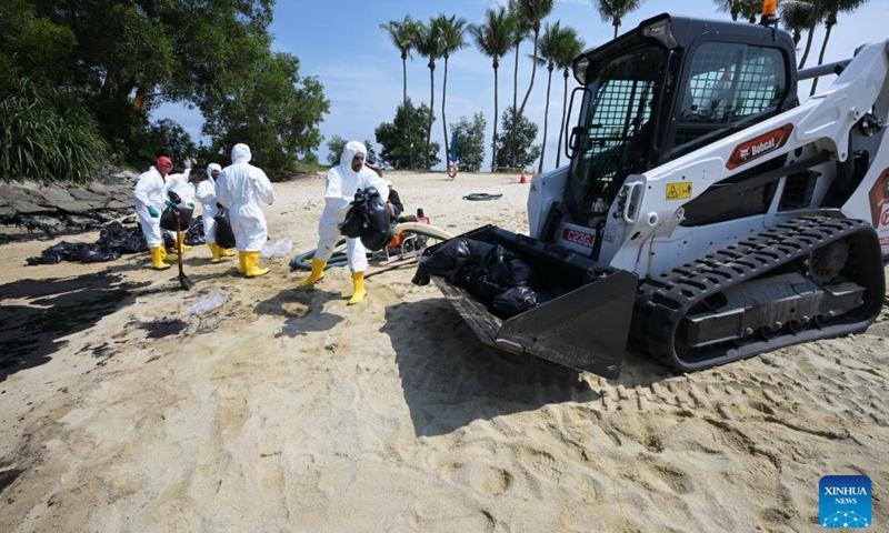 Workers clean up the oil spill on Tanjong beach on Sentosa island in Singapore, June 16, 2024. (Photo: Xinhua)