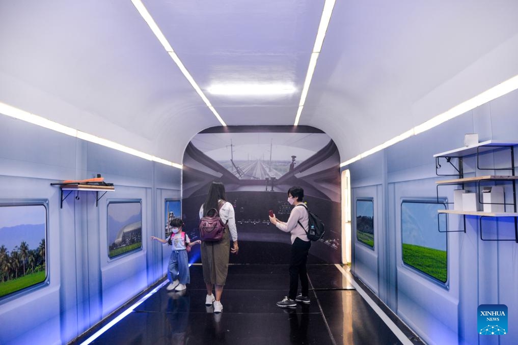Passengers take photos inside a decoration resembling the interior view of the driver's cab of a high-speed electrical multiple unit (EMU) train of the Jakarta-Bandung high-speed railway, at the waiting hall of Halim Station in Jakarta, Indonesia, June 17, 2024.(Photo: Xinhua)