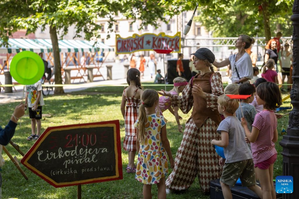 Children watch plate spinning during the international festival of contemporary clown and new circus in Ljubljana, Slovenia, on June 17, 2024. The international festival of contemporary clown and new circus is held here from June 17 to June 23.(Photo: Xinhua) 