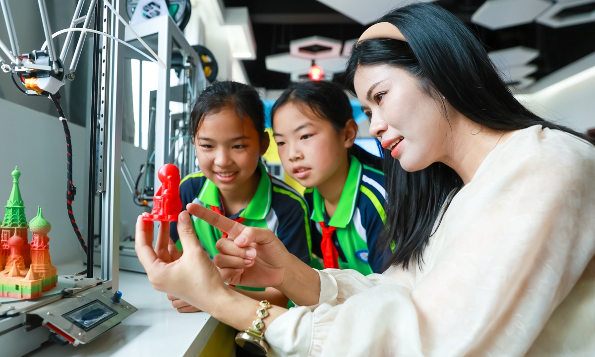 Primary school students learn about the principles and design creation of 3D printing equipment under the guidance of their teacher in Jiujiang, East China's Jiangxi Province, on June 20, 2024. The school has introduced high-tech devices such as 3D printers into the campus and offered special technology courses, aiming to cultivate students' hands-on practical abilities and better promote the overall quality improvement of students. Photo: VCG