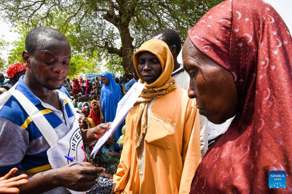 A staff member of International Committee of the Red Cross (ICRC) registers information of beneficiaries before the distribution of food and seeds in Hile Alifa, Cameroon, June 12, 2024.(Photo: Xinhua)