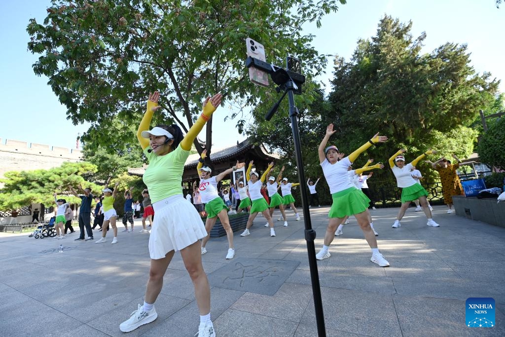 Photo taken on June 12, 2024 shows residents practicing group dance near ancient city wall in Xi'an, northwest China's Shaanxi Province. Xi'an, a city with over 3,100 years of history, served as the capital for 13 dynasties in Chinese history. It is also home to the world-renowned Terracotta warriors created in the Qin Dynasty (221-207 BC).(Photo: Xinhua)