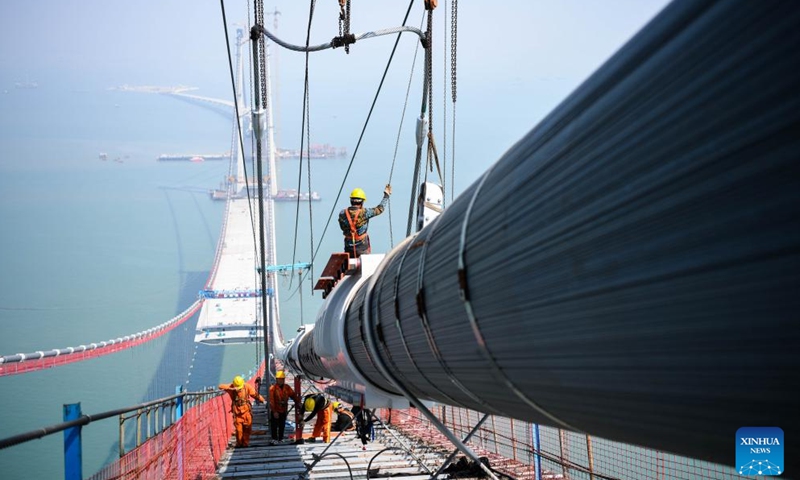 Workers work on the Shenzhong Bridge of the Shenzhen-Zhongshan link under construction in south China's Guangdong Province, Feb. 22, 2023.