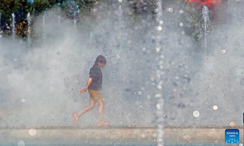 A child passes through the spray of a public fountain to cool off amid a heatwave in Bucharest, Romania, June 22, 2024. (Photo: Xinhua)