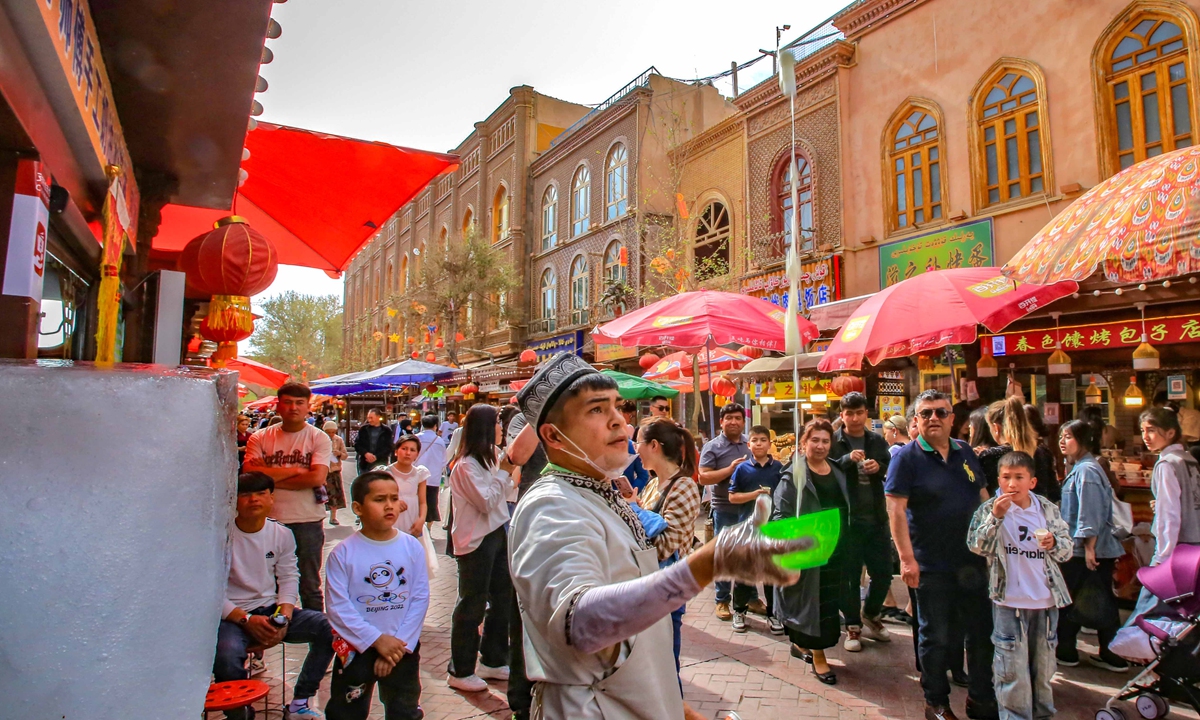 A vendor in the Ancient City of Kashi makes ice yogurt for customers. Photo: VCG
