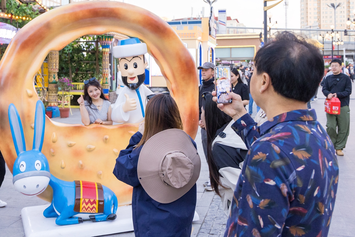 Tourists take photos at the grand bazaar in Urumqi. Photo: VCG