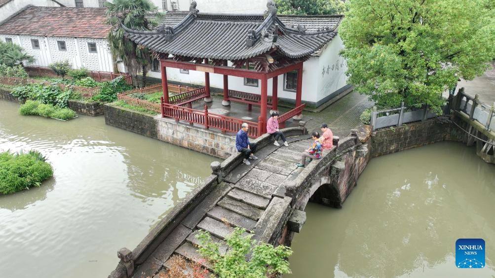 An aerial drone photo taken on June 26, 2024 shows people resting on the Wanshan Bridge in Shebei Village of Xin'an Town, Deqing County, east China's Zhejiang Province. Deqing County is home to seven ancient stone bridges which are listed as major cultural heritage sites under state-level protection. (Photo: Xinhua)