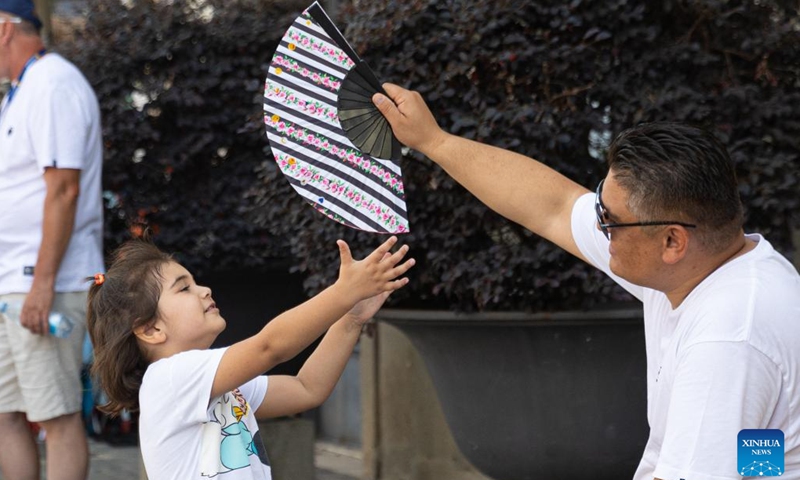 A parent cools his child off in Rome, Italy, June 29, 2024. (Xinhua/Li Jing)