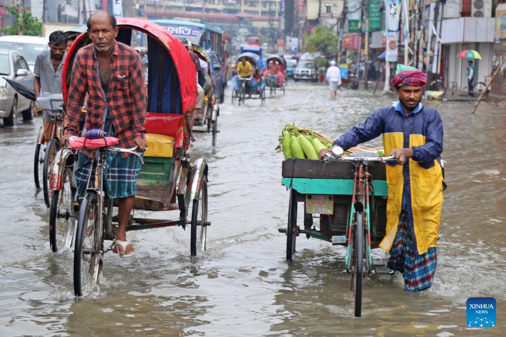People and vehicles are pictured on a flooded road in Dhaka, Bangladesh, July 2, 2024. Recently, continuous rain has drenched the capital city, causing severe waterlogging. (Photo: Xinhua)
