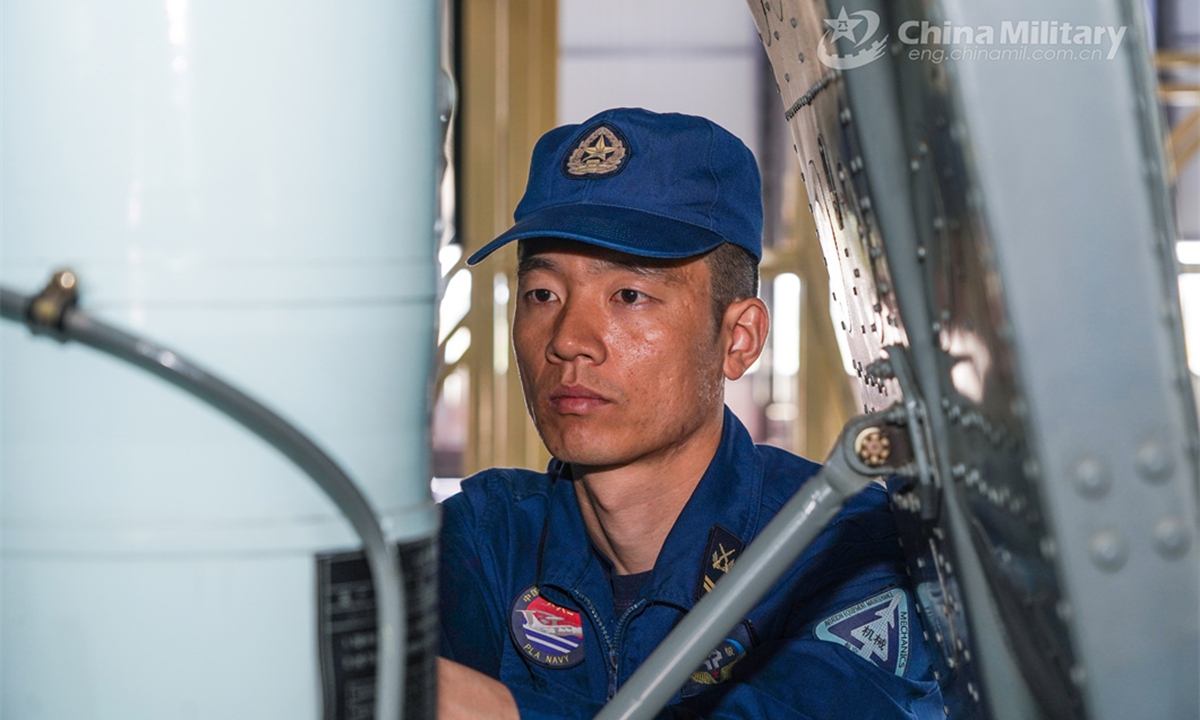 A ground crew member assigned to a PLA naval aviation regiment conducts pre-flight inspection prior to a round-the-clock flight training exercise. (eng.chinamil.com.cn/Photo by Yang Jian)