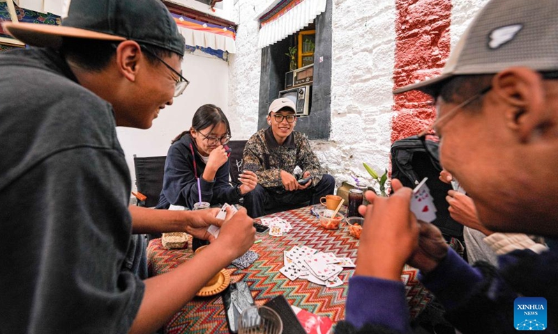 Customers play a poker game at a cafe on the Barkhor Street in Lhasa, southwest China's Xizang Autonomous Region, July 5, 2024.