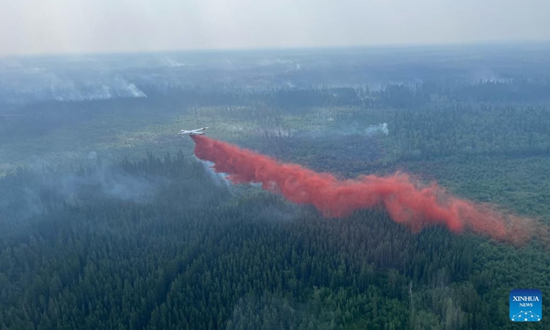 Aerial photo provided by Alberta Wildfire shows a firefighting plane dropping fire retardant on a wildfire in northern Alberta, Canada, on July 5, 2024. Sweltering conditions from a heat wave gripping Western Canada presented challenging conditions for firefighters in northern Alberta on July 9. Wildfire danger warnings spread across Alberta over the weekend with extreme temperatures and out-of-control fires in the northern areas of the province. (Photo: Xinhua)