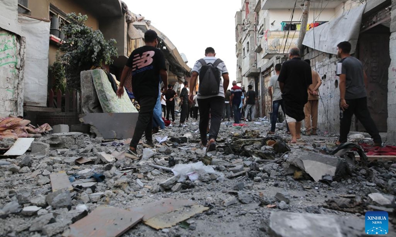 People gather at a building destroyed in an Israeli airstrike in Al-Maghazi refugee camp, central Gaza Strip, on July 15, 2024. (Photo: Xinhua)