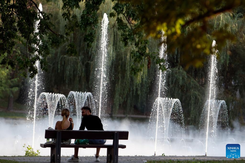 A couple sits on a bench in the shade at a park in Bucharest, Romania, on July 17, 2024. The Romanian National Meteorological Administration (ANM) has extended its red and orange heat warnings until Wednesday, affecting the entire country amid an ongoing heatwave. (Photo: Xinhua)