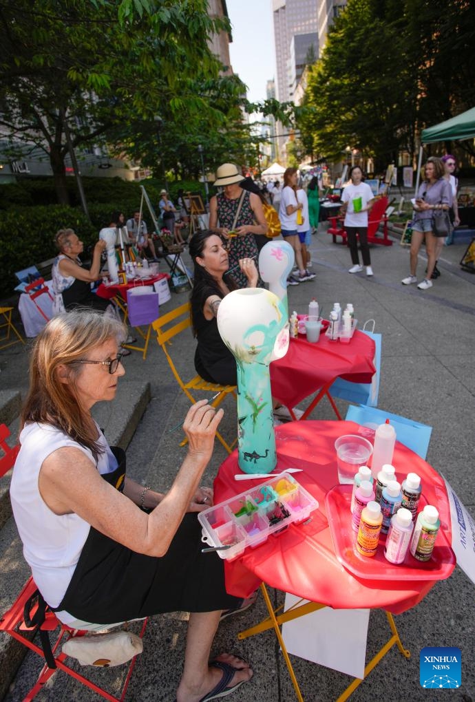 Artists work on their paintings on vases during the Art Masters painting competition in Vancouver, British Columbia, Canada, on July 17, 2024. The Art Masters is a painting competition with professional artists completing their works within one hour by using various supplies other than brushes. (Photo: Xinhua)