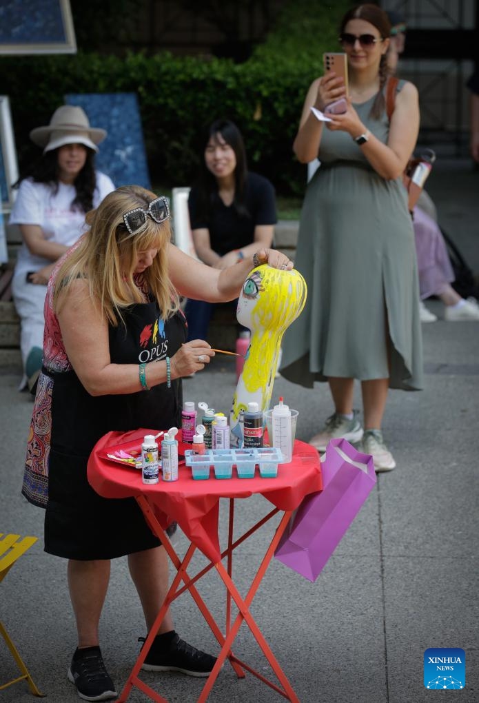 An artist works on her painting on a vase during the Art Masters painting competition in Vancouver, British Columbia, Canada, on July 17, 2024. The Art Masters is a painting competition with professional artists completing their works within one hour by using various supplies other than brushes. (Photo: Xinhua)