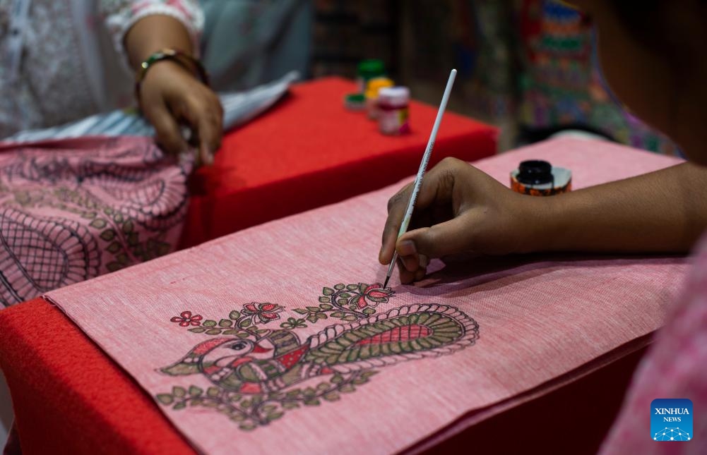 Indian artisans create Madhubani paintings on clothes at an exhibition titled Incredible India in New Delhi, India, July 22, 2024. The exhibition is set up to highlight India's rich cultural heritage, age-old civilization, geographical diversity, and tourism destinations. (Photo: Xinhua)