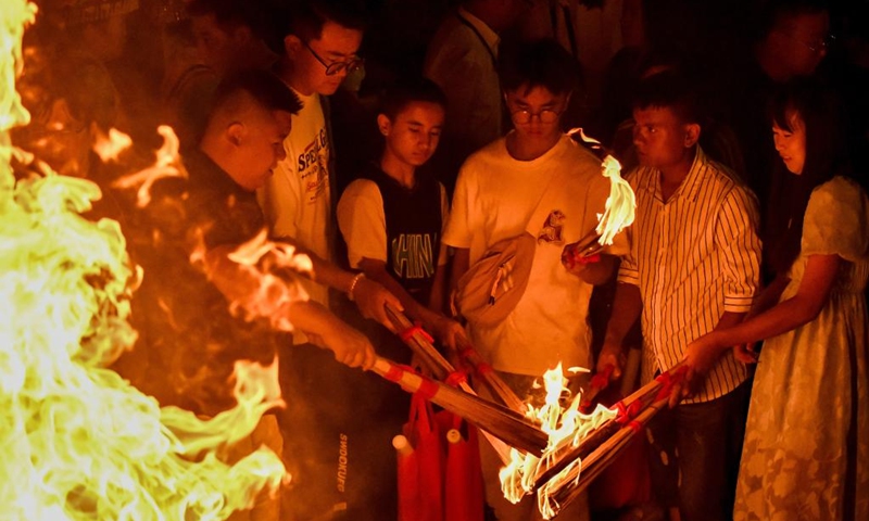 People light torches at a torch festival in Chuxiong, southwest China's Yunnan Province, July 27, 2024. A torch festival of the Yi ethnic group kicked off here on Saturday. Photo: Xinhua
