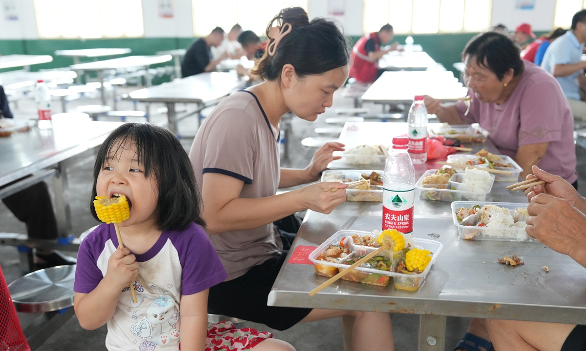 Villagers have lunch at a resettlement site in Xiangtan county, Central China's Hunan Province, on July 29, 2024. More than 3,800 people in the area were safely relocated after breaches occurred in the embankment of a tributary of the Xiangjiang River in Hunan Province in Typhoon Gaemi's wake. Photo: VCG