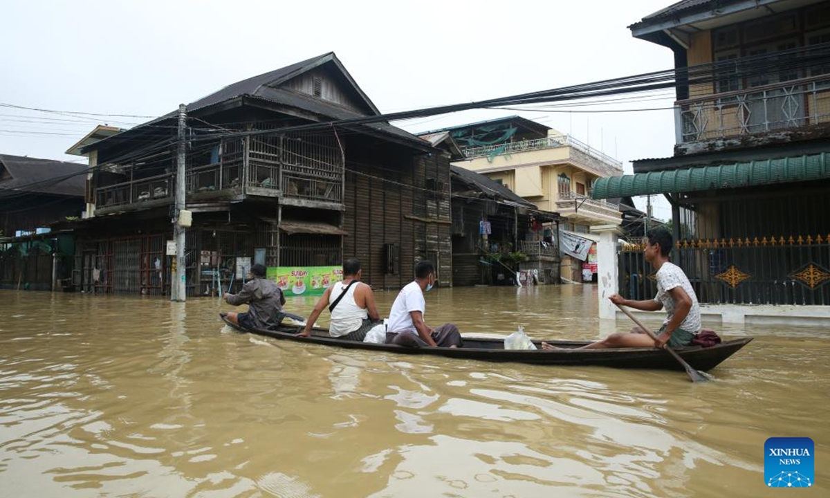 People row a wooden boat on flood water in Bago Region of southern Myanmar, July 29, 2024. (Photo: Xinhua)