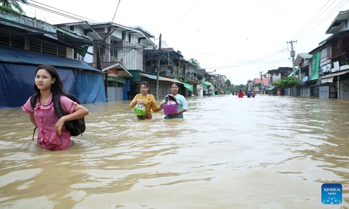 People wade through a flooded area in Bago Region of southern Myanmar, July 29, 2024. (Photo: Xinhua)
