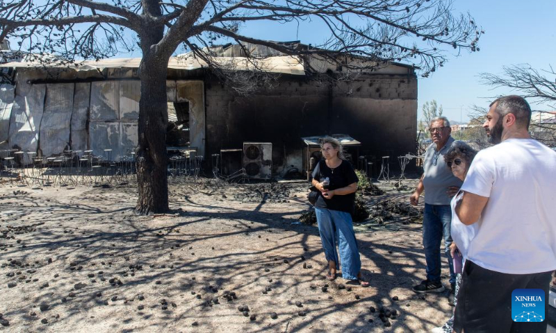 People check a factory damaged by wildfire in Chalandri, a suburb in northern Athens, Greece, on Aug. 13, 2024. (Photo: Xinhua)