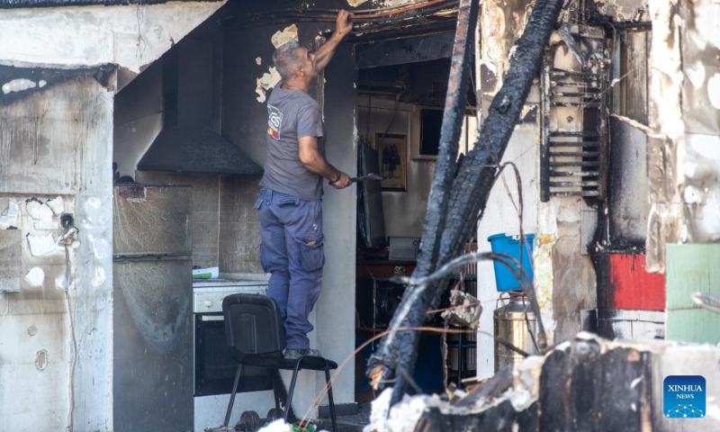 A man repairs a house damaged by wildfire in Chalandri, a suburb in northern Athens, Greece, on Aug. 13, 2024. (Photo: Xinhua)