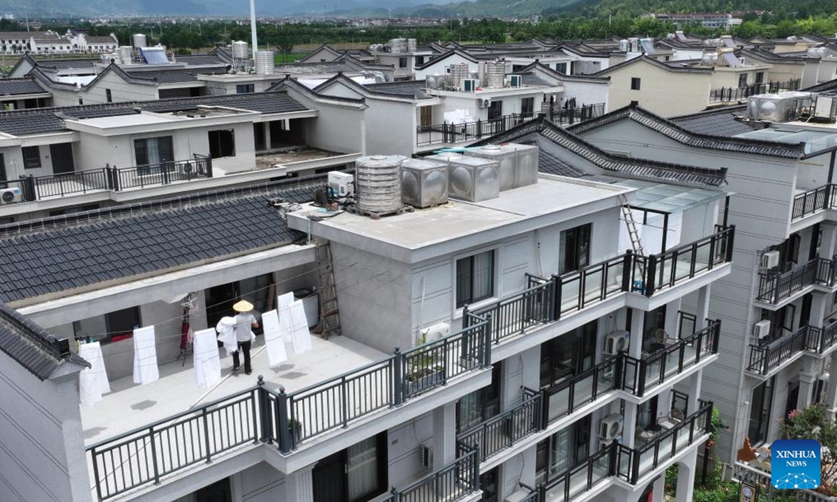 A homestay worker airs bedding in Shangye Village of Baita Town in Xianju County, east China's Zhejiang Province, July 28, 2024. Xianju County is rich in tourism resources. By tapping local characteristic cultural resources and introducing high-end boutique homestay projects, the local government has turned resource advantages into industrial advantages, igniting a new engine for rural revitalization.  (Photo: Xinhua)