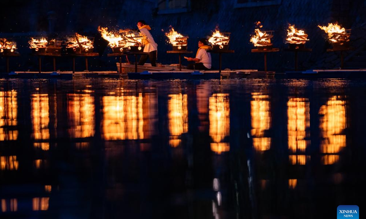 Staff members put wooden chips bearing blessing messages into braziers in commemoration of atomic bombing victims at Hiroshima Peace Memorial Park in Hiroshima, Japan, Aug. 5, 2024. As Japan marked the anniversary of atomic bombing on the western city of Hiroshima on Tuesday, people from across the nation gathered to protest the government's accelerated arms build-up, urging it to stick to peace. (Photo: Xinhua)
