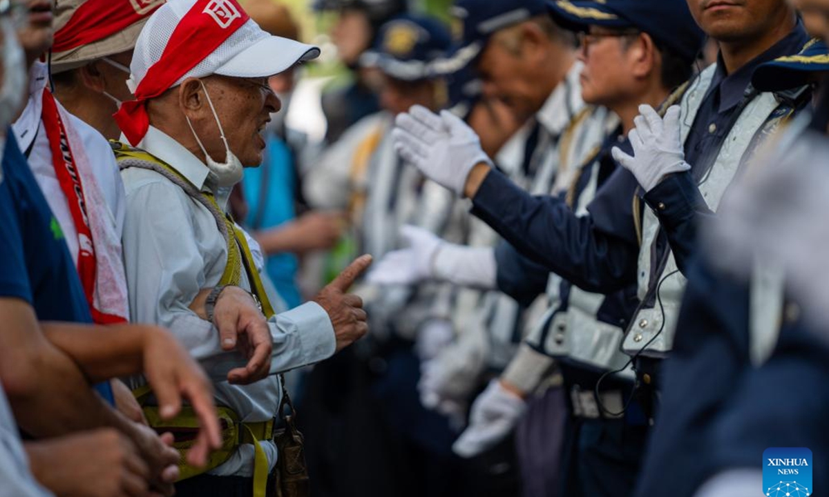 Protesters confront security personnel at Hiroshima Peace Memorial Park in Hiroshima, Japan, Aug. 6, 2024. As Japan marked the anniversary of atomic bombing on the western city of Hiroshima on Tuesday, people from across the nation gathered to protest the government's accelerated arms build-up, urging it to stick to peace. (Photo: Xinhua)