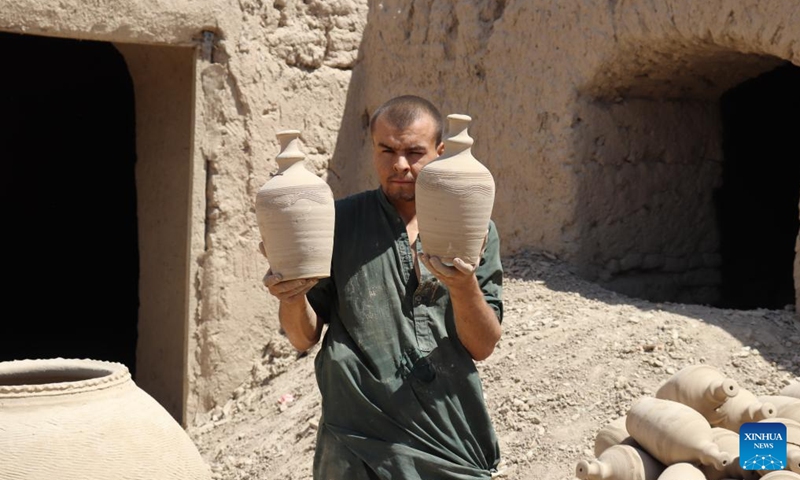 A potter carries pottery pots in Dawlat Abad District, north Afghanistan's Balkh province, Aug. 7, 2024. (Photo: Xinhua)