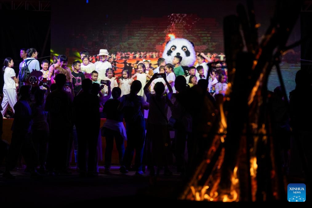 Tourists take pictures at a bonfire gala in Muyu Town of Shennongjia Forest District, central China's Hubei Province, Aug. 6, 2024. (Photo: Xinhua)