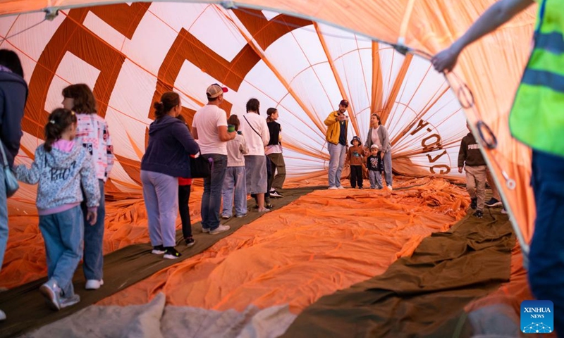People pose for photos inside a hot-air balloon during the Sky of Russia hot-air balloon festival in Ryazan region, Russia, on Aug. 9, 2024. The 22nd ballooning festival Sky of Russia is held here from Aug. 4 to 12, and more than 30 teams are featured in the festival. Photo: Xinhua