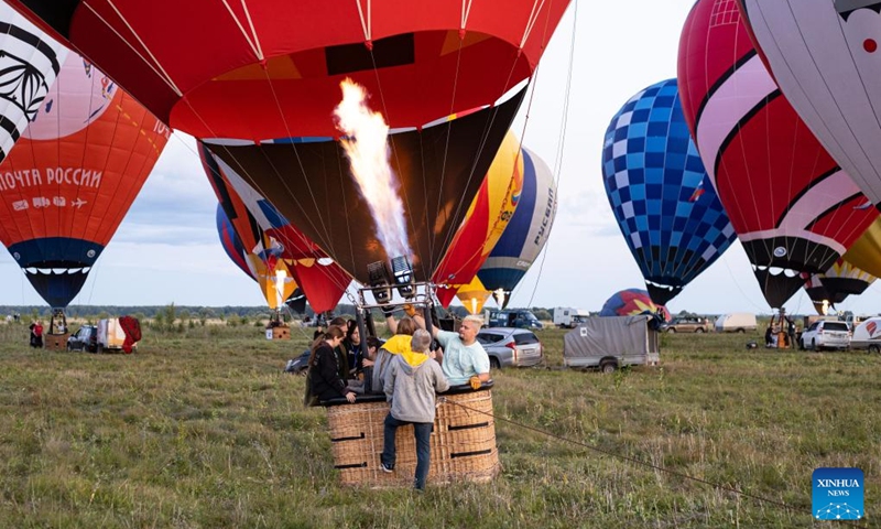 People inflate a hot-air balloon during the Sky of Russia hot-air balloon festival in Ryazan region, Russia, on Aug. 9, 2024. The 22nd ballooning festival Sky of Russia is held here from Aug. 4 to 12, and more than 30 teams are featured in the festival. Photo: Xinhua