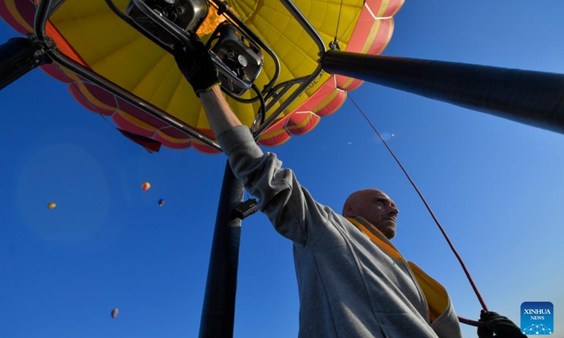 A pilot inflates a hot-air balloon during the Sky of Russia hot-air balloon festival in Ryazan region, Russia, on Aug. 10, 2024. The 22nd ballooning festival Sky of Russia is held here from Aug. 4 to 12, and more than 30 teams are featured in the festival.  Photo: Xinhua