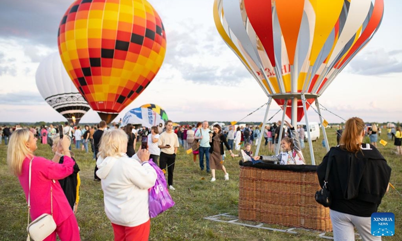 A girl poses for photos in a hot-air balloon during the Sky of Russia hot-air balloon festival in Ryazan region, Russia, on Aug. 9, 2024. The 22nd ballooning festival Sky of Russia is held here from Aug. 4 to 12, and more than 30 teams are featured in the festival. Photo: Xinhua