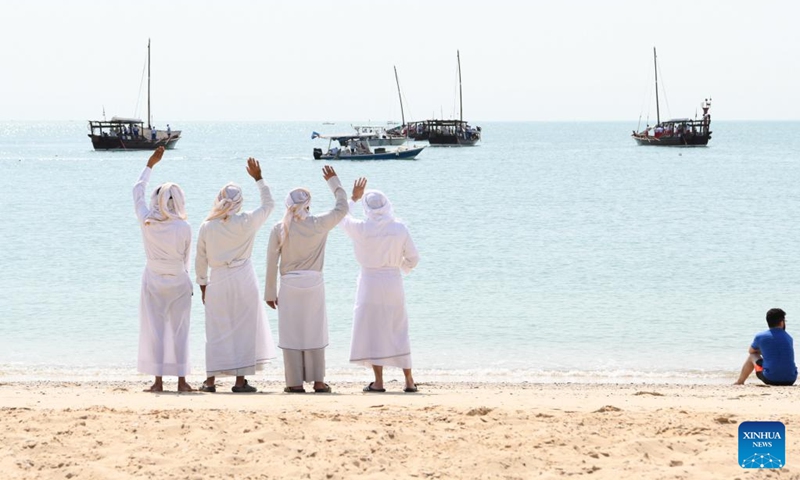 People wave to dhow boats carrying divers during the inauguration of the 33rd Pearl Diving Festival at a dock in Al-Salmiya, Hawalli Governorate, Kuwait, Aug. 10, 2024. The 33rd Pearl Diving Festival kicked off here Saturday, with up to 150 young sailors and divers boarding several dhow boats to embark on a pearl-finding trip that lasts for 6 days. Photo: Xinhua