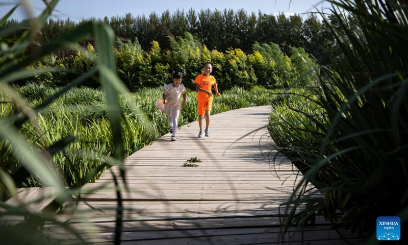 Tourists visit Guchengwan artificial wetland in the Litong District of Wuzhong City, northwest China's Ningxia Hui Autonomous Region, Aug. 10, 2024. Wuzhong has a piece of artificial wetland called Guchengwan that plays a vital role in the Yellow River's ecological environment. Part of a wastewater disposal system, the wetland follows the natural working way of waste and pollution disposal in natural wetlands. With an investment of 98 million yuan (about $13.7 million), the wetland supports a waste disposal facility that further purifies already-treated water, ensuring high-quality soil water in the region. Photo: Xinhua