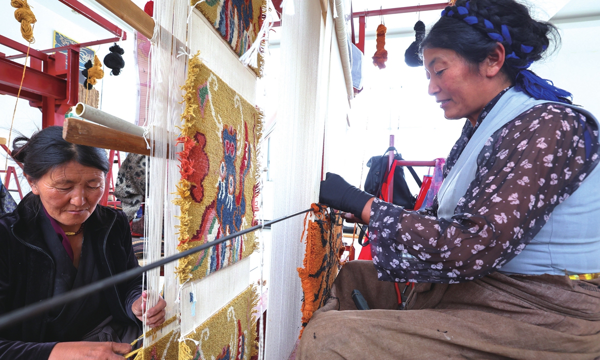 Two local women weave carpets at a workroom in Qiongjie county, Southwest China's Xizang Autonomous Region on August 12, 2024.  Weaving carpets has helped farmers and herdsmen increase their incomes, as hand-woven Tibetan carpets are exported to overseas markets. Photo: VCG 