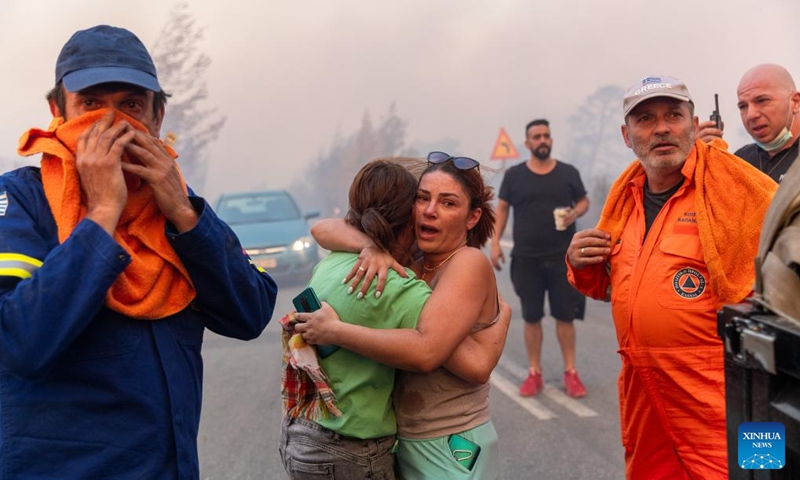 Local residents and firefighters are seen at the site of a wildfire in Varnavas, around 35 km from Athens, Greece, on Aug. 11, 2024. Greek firefighters were battling a major wildfire for several hours on Sunday near Athens, which has forced the evacuation of five settlements, the Fire Brigade said. Five residents among the evacuees were transferred to hospitals with minor injuries, mostly from respiratory problems due to smoke inhalation, said Health Minister Adonis Georgiadis. The fire broke out around 3 pm local time in Varnavas, around 35 km from Athens, in the northeastern Attica region near Marathon. Photo: Xinhua